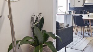 Una cocina moderna con comedor, un espejo grande y una planta en maceta.