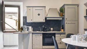 Una cocina moderna con horno integrado, cafetera y hervidor sobre la encimera.