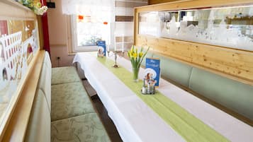 A hotel room with a long table, a bench, and a wall display.