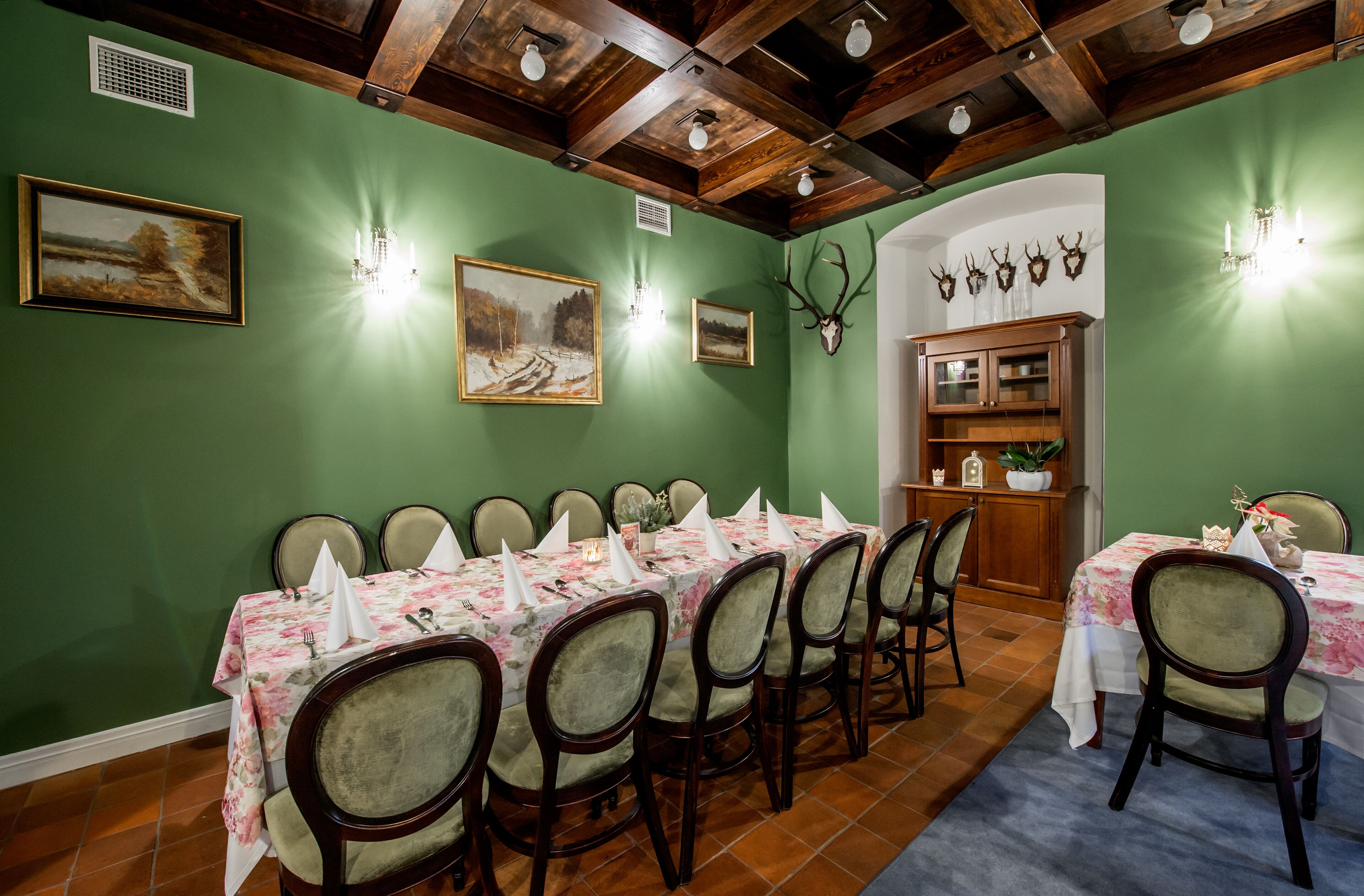 A dining room with a long table set for a meal, surrounded by chairs.