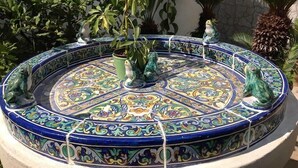 Una fuente decorativa con detalles de azulejos intrincados y estatuas de ranas.