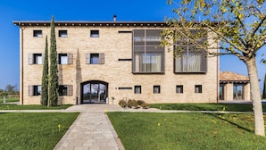 A two-story building with a brick facade, large windows, and a central entrance. - Agriturismo La Razza (Reggio nell'Emilia)