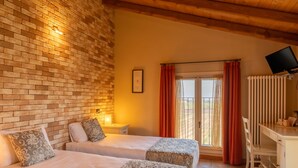 A room with two beds, a desk, a TV, and a window with curtains. - Agriturismo La Razza (Reggio nell'Emilia)