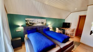 Una habitación de hotel moderna con una cama grande, un escritorio y una televisión.