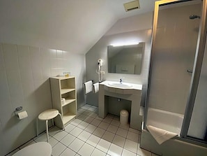 A small, modern bathroom with a shower, a sink, and a toilet.