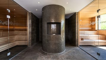 Relax in a serene sauna with a mosaic-tiled wall and wooden bench area.