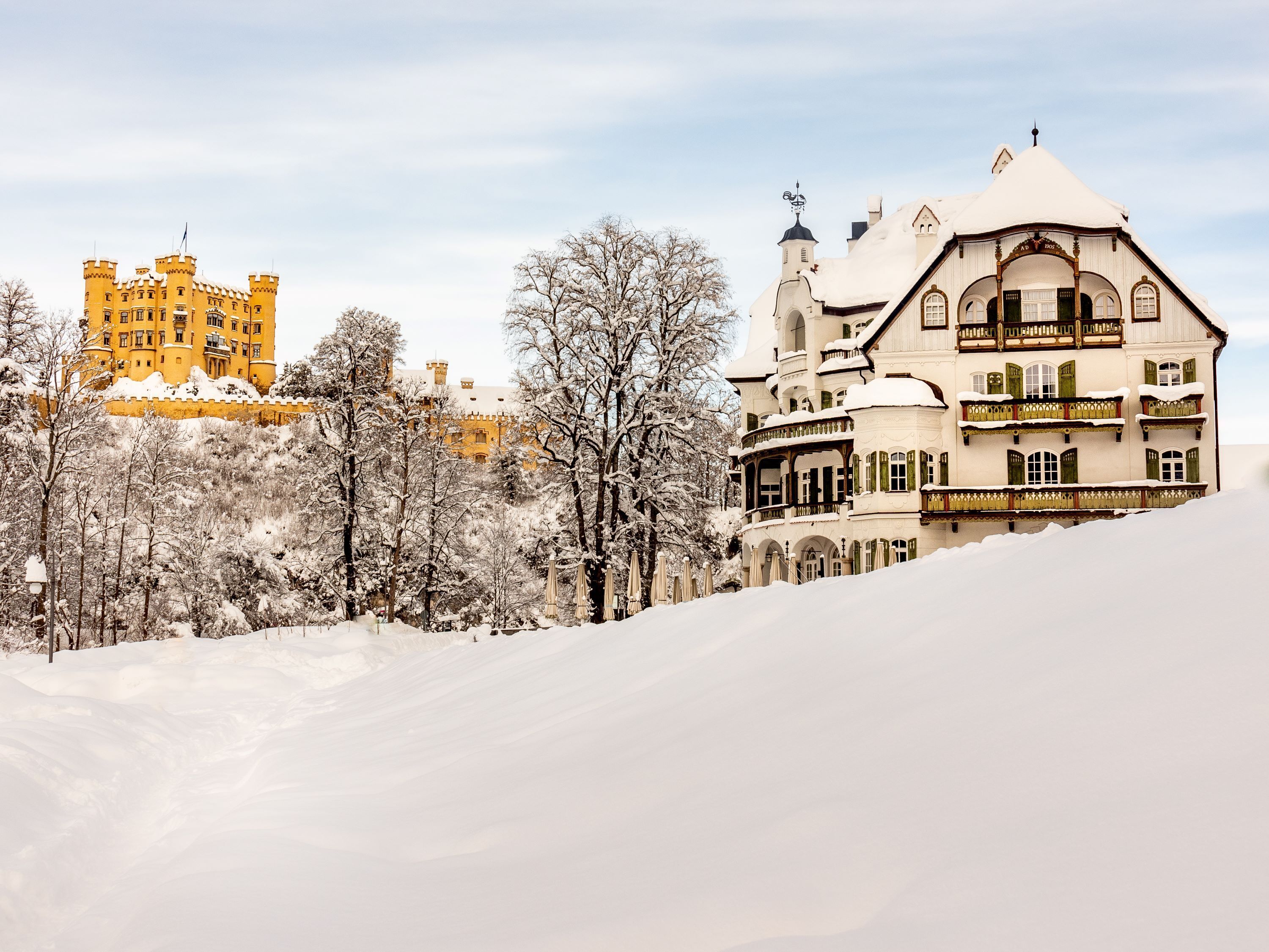 Un paisaje nevado con un castillo y un edificio con balcones.