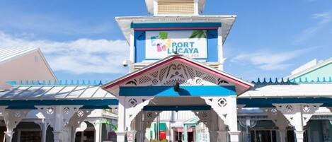 A hotel entrance with a sign reading "Port Lucaya Place" and a covered walkway.