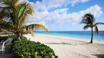 Di pantai, pasir putih, dan rumah kecil pinggir pantai gratis