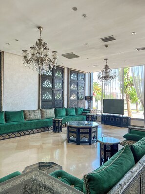 A spacious living area with a large sofa set, a coffee table, and a TV.