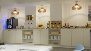 Eine moderne Küche mit weißen Schränken, einer Kaffeemaschine und verschiedenen Lebensmitteln auf der Arbeitsfläche.