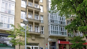 Ein mehrgeschossiges Gebäude mit Eingang im Erdgeschoss, großen Fenstern und Balkonen.