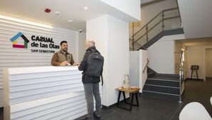 Ein Empfangstresen mit einem Schild, auf dem "CASUAL de las Olas SAN SEBASTIÁN" steht, und eine Treppe im Hintergrund.