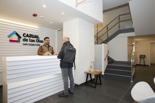 Una recepción con un cartel que dice "CASUAL de las Olas SAN SEBASTIÁN" y una escalera al fondo.