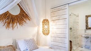A bedroom with a bed, a wall-mounted light fixture, and a sliding door leading to a bathroom. - Garam Lisboa (Lisbon)