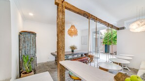 A rustic interior with a long table, wooden beams, and a hanging light fixture. - Garam Lisboa (Lisbon)
