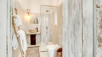 A bathroom with a shower, toilet, and sink.