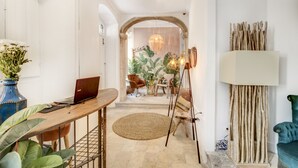 A modern interior with a wooden desk, laptop, and a hanging light fixture. - Garam Lisboa (Lisbon)