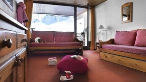 Una habitación acogedora con una cama, un sofá y un aparador de madera.