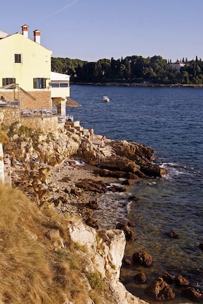A coastal building with a stone facade, a balcony, and a view of the sea. - Villa Segalla (Rovinj)