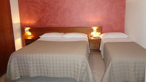 A hotel room with two single beds, each with a wooden headboard and bedside lamps. - Hotel Millennium (Orte)