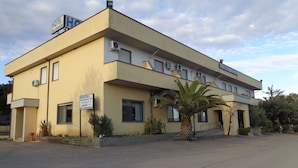 A two-story building with a sign indicating it is a hotel named 'Hotel Millennium'. - Hotel Millennium (Orte)