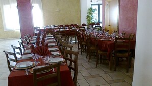 A dining area with multiple tables set for a meal, each with chairs and table settings. - Hotel Millennium (Orte)