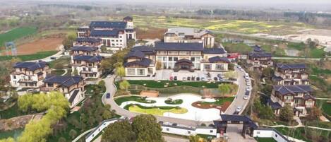 A residential area with multiple houses, a central landscaped area, and a road.