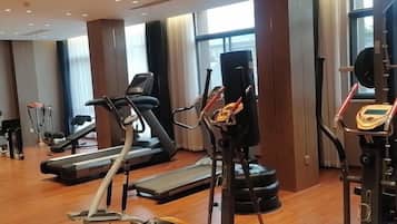 A gym with cardio machines, weightlifting equipment, and a treadmill.