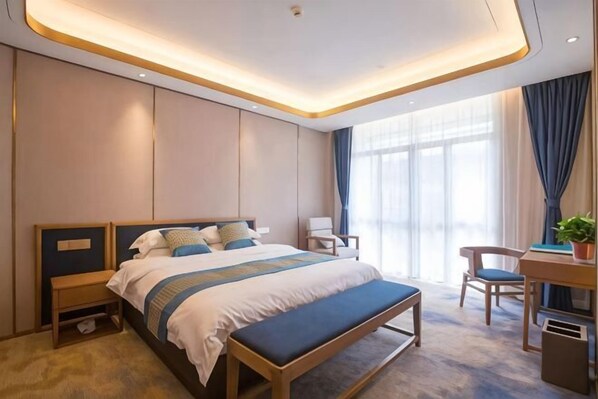 A modern hotel room with a large bed, bedside tables, a desk, and a chair. - Zaolin Mountain Villa (Yizheng)