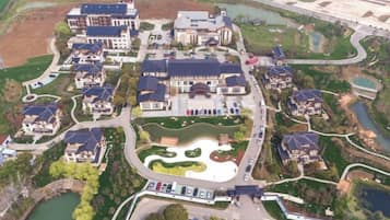 Zona residencial con varias casas, un área ajardinada central y una masa de agua.