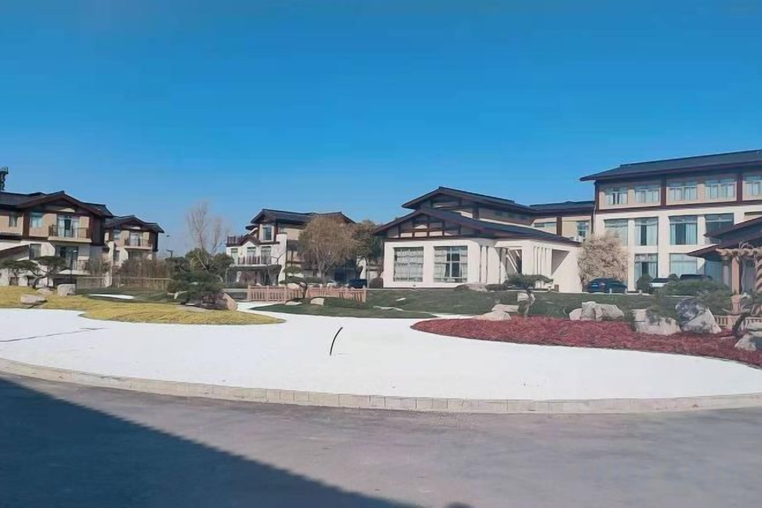 A residential area with modern houses, a clear sky, and a well-maintained lawn.