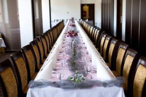 A long dining table with chairs, set for a formal meal.