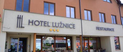 A hotel with a sign reading 'HOTEL LUZNICE' and a restaurant named 'RESTAURACE'.