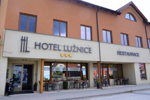 Un hôtel avec une enseigne indiquant « HÔTEL LUZNICE » et un restaurant appelé « RESTAURACE ».