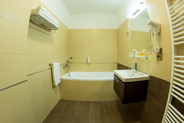 A bathroom with a bathtub, a sink, a towel rack, and a mirror.