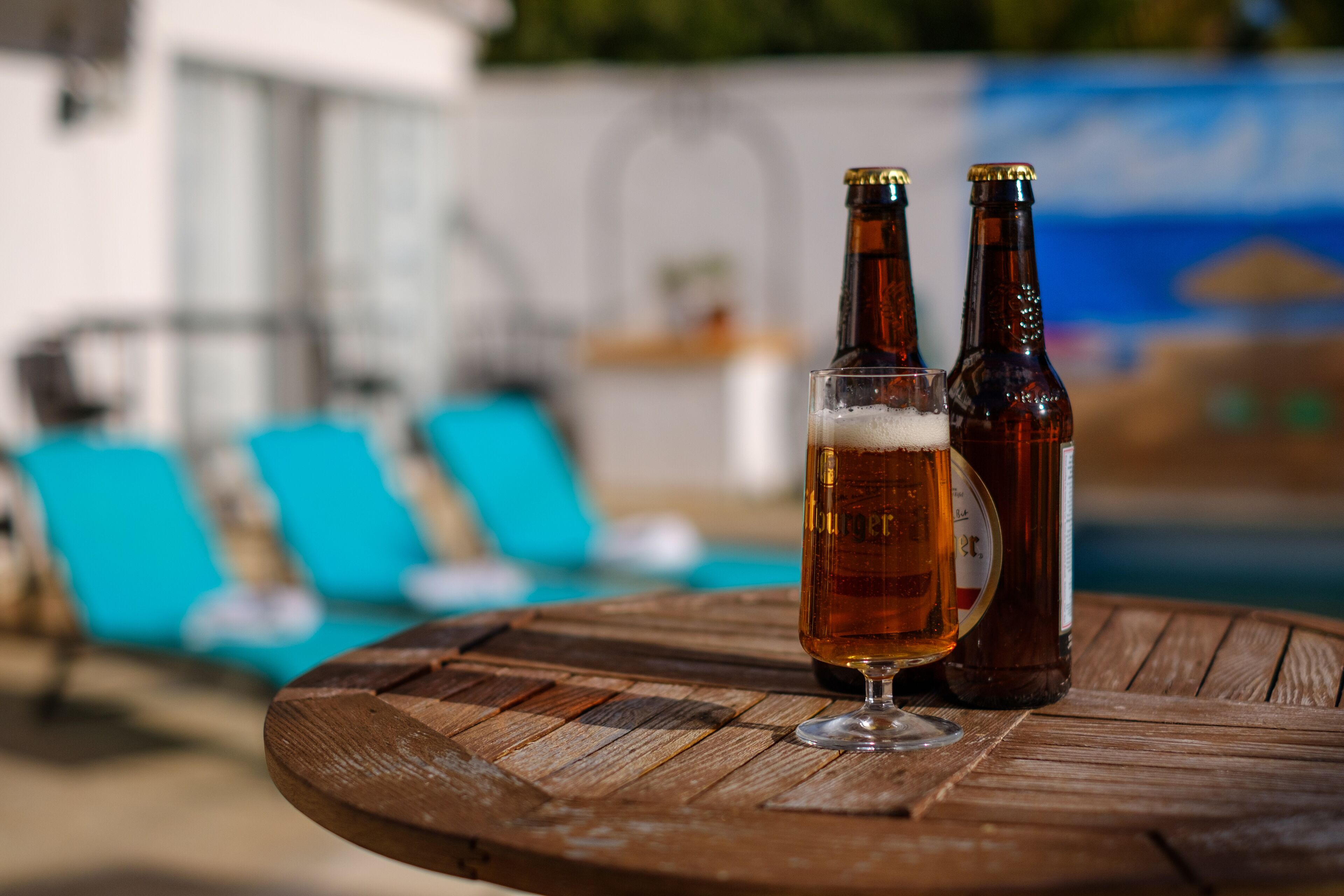 Una mesa de madera con dos botellas de cerveza y una jarra.