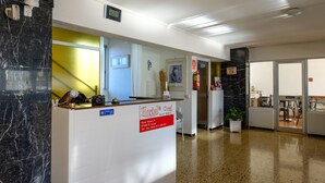 Una recepción con un letrero que indica la ubicación y la información de contacto del Hostal* Orsi.