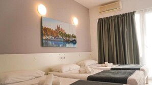 A hotel room with two beds, a painting of a cityscape, an air conditioning unit, and a window with curtains. - Xapala (MALLORCA)