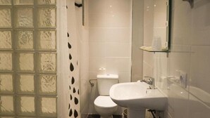 A bathroom with a toilet, sink, and glass shower enclosure. - Xapala (MALLORCA)