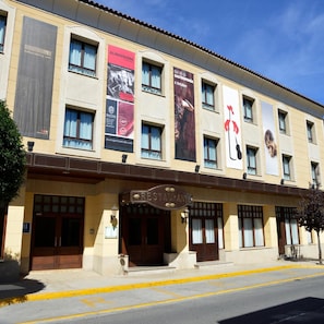 Un edificio con varios pancartes anunciando eventos y un letrero de restaurante.