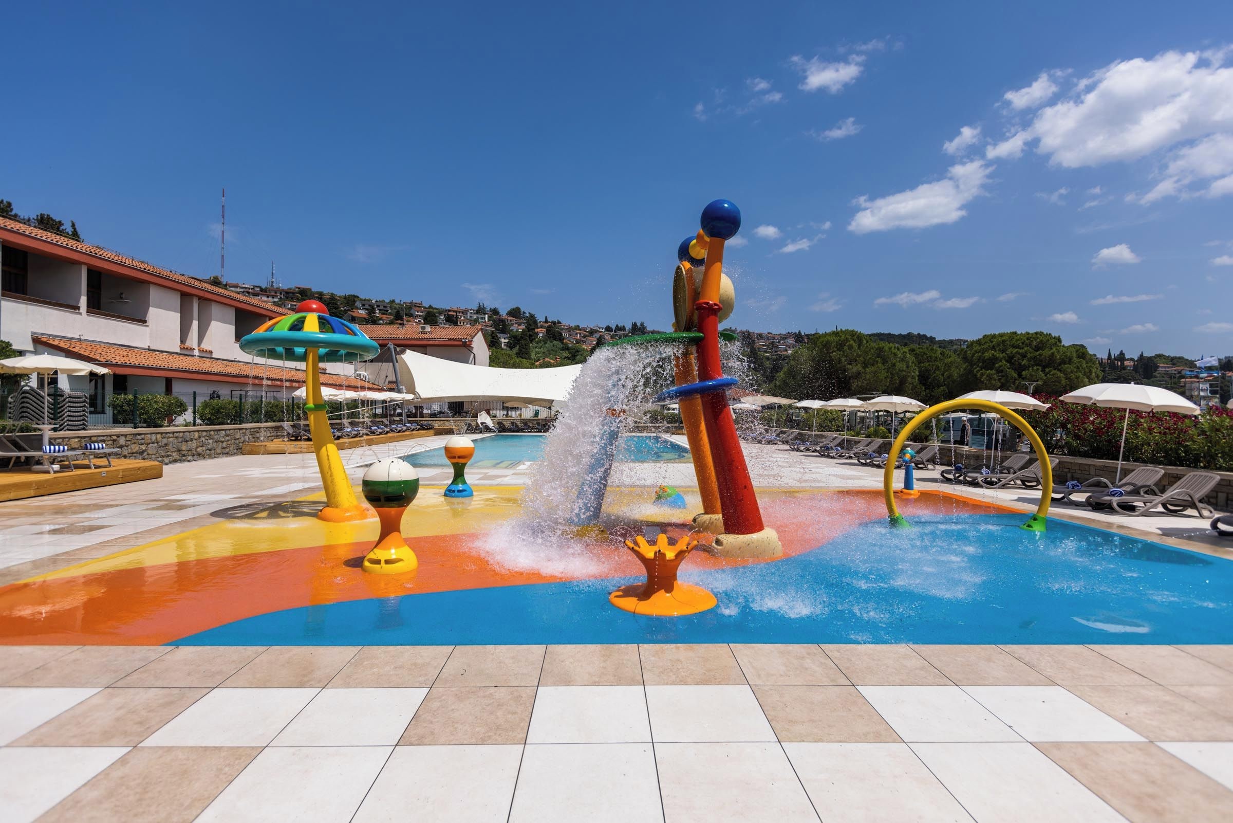 A water play area with colorful structures and a pool.