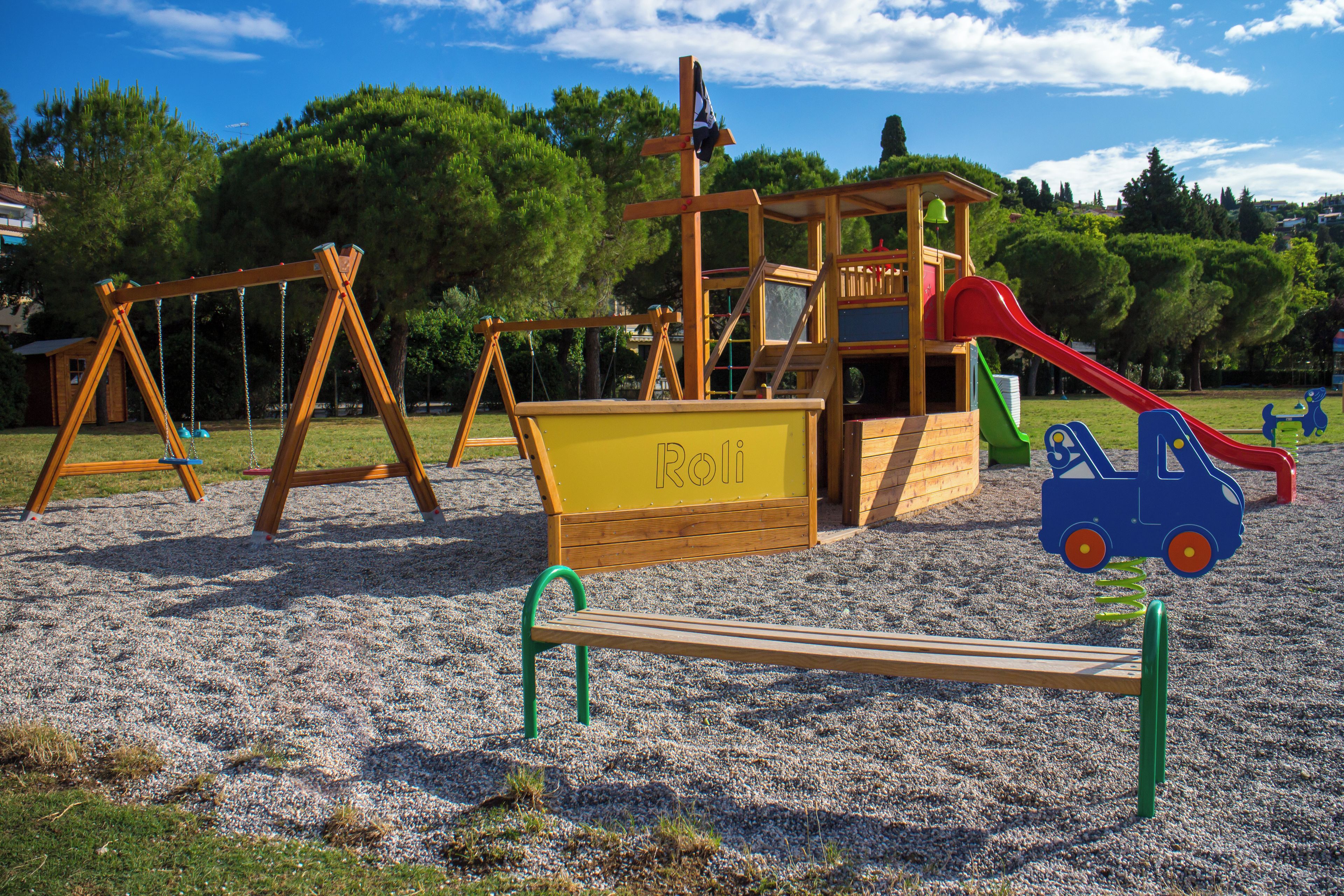A playground with swings, a slide, and a sandbox labeled "Roh".