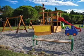 A playground with swings, a slide, and a sandbox labeled "Roh". - Hotel Vile Park Premium (Piran)