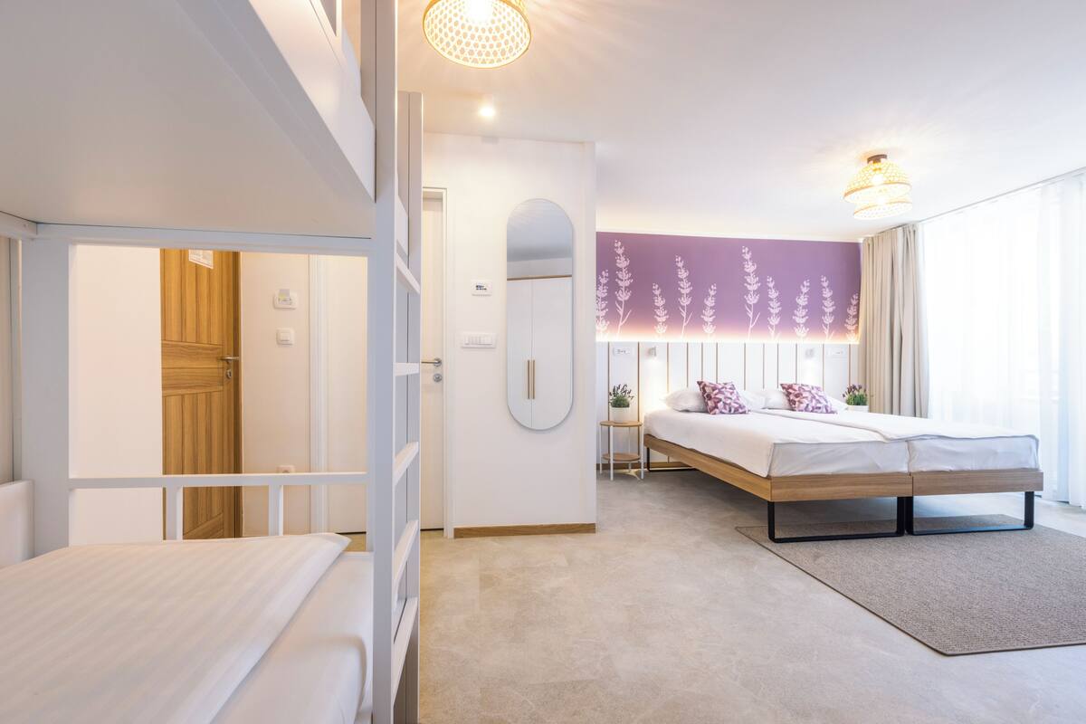Una habitación de hotel moderna con una cama, un escritorio y vistas al exterior.
