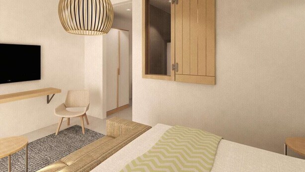 A modern bedroom with a bed, a chair, a TV, a wardrobe, and a hanging light fixture. - Hotel Vile Park Premium (Piran)