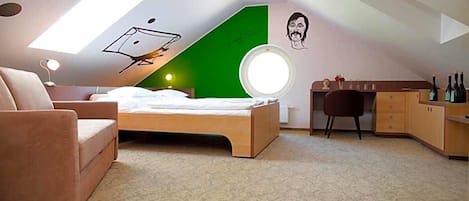 A bedroom with a bed, a desk, a chair, a wardrobe, a round mirror, and a skylight.