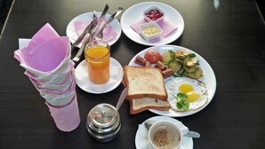 A breakfast setting with toast, eggs, potatoes, tomatoes, and a cup of coffee. - Sauraha Boutique Resort (Sauraha)