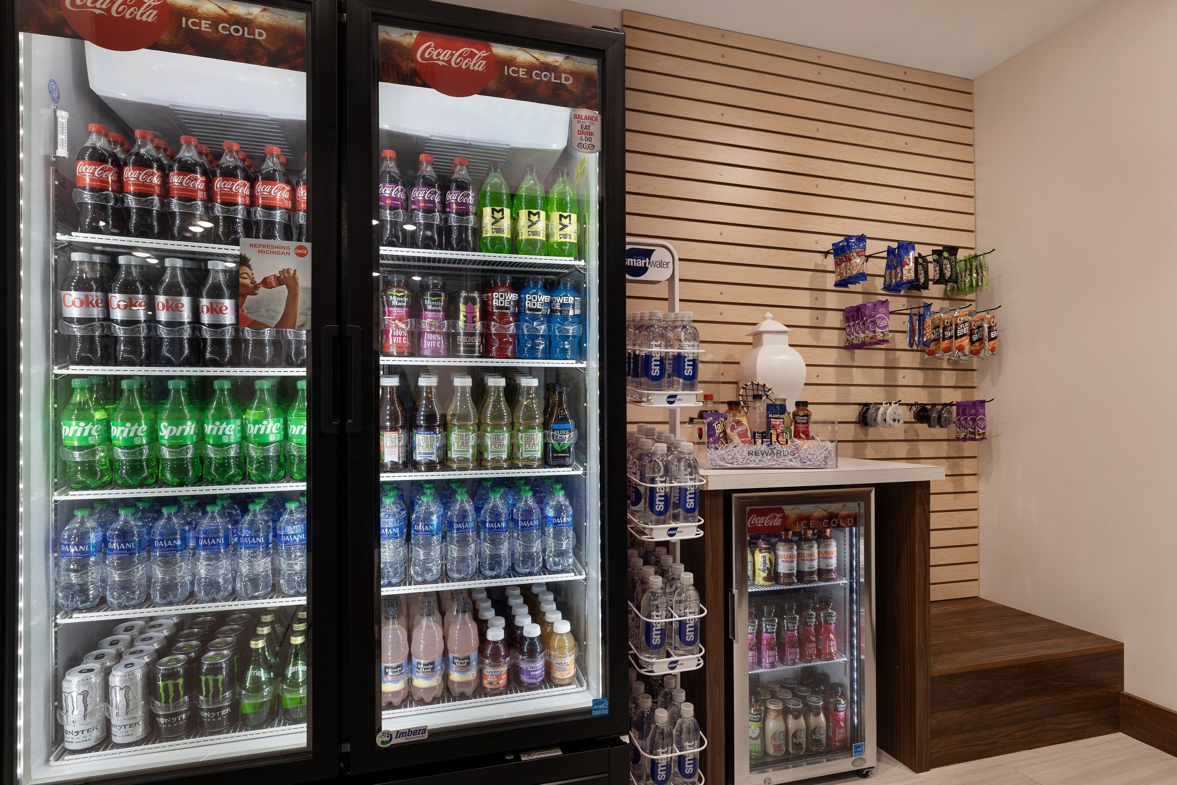 A vending area with Coca-Cola and Sprite coolers, water bottles, and snacks.