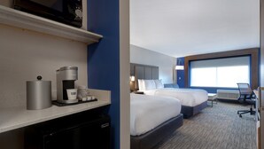 A hotel room with a kitchenette, two beds, a large window, and a desk with a chair. - Holiday Inn Express & Suites Brighton by IHG (Brighton)